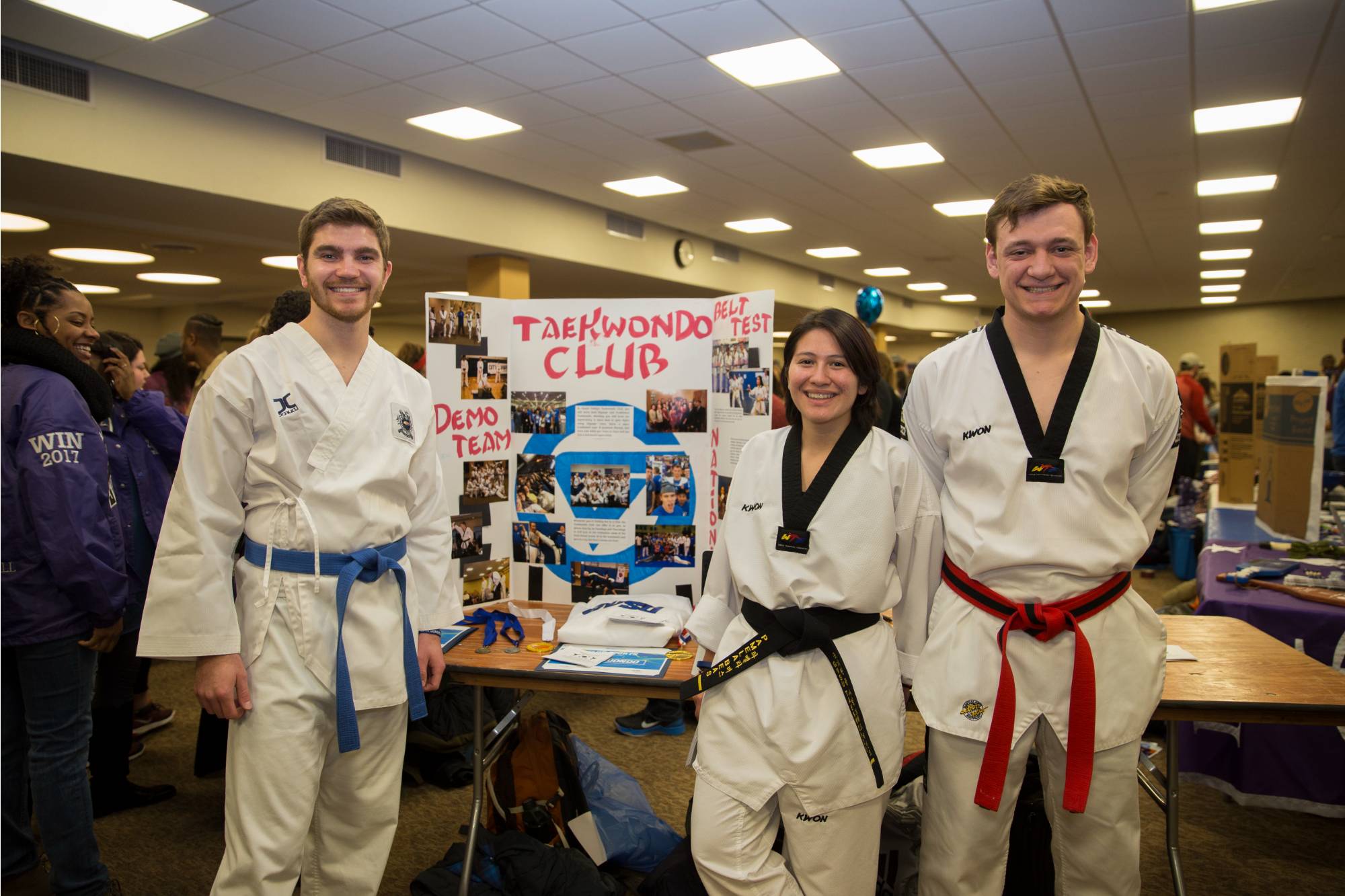 The taekwondo club smiling in front of their sign at campus life night